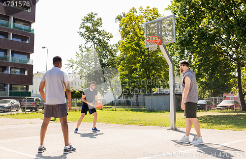 Image of group of male friends playing street basketball