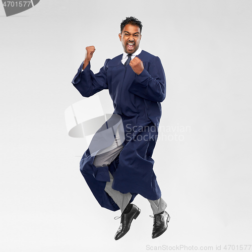 Image of happy male indian graduate student jumping