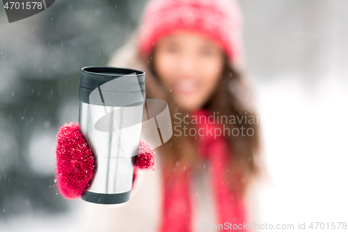 Image of hand holding tumbler or thermo cup in winter