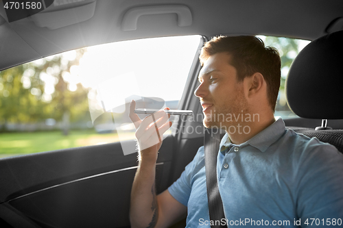 Image of passenger recording voice on smartphone in car