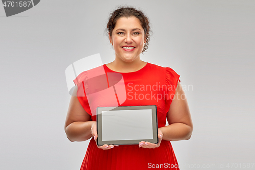 Image of happy woman in red dress holding tablet computer