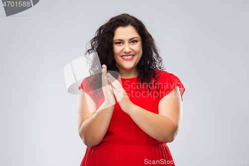 Image of happy woman in red dress applauding