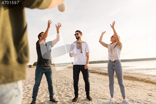 Image of friends playing volleyball on beach in summer