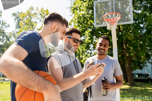 Image of men with smartphone at basketball playground