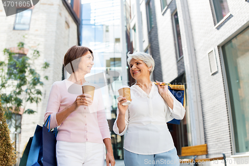 Image of senior women with shopping bags and coffee in city