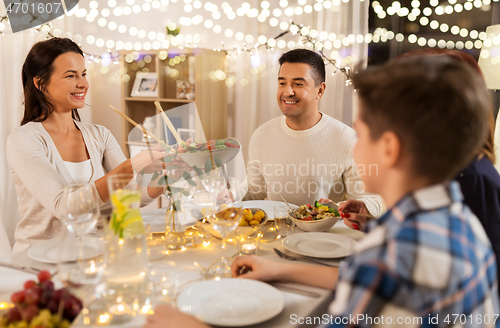 Image of happy family having dinner party at home