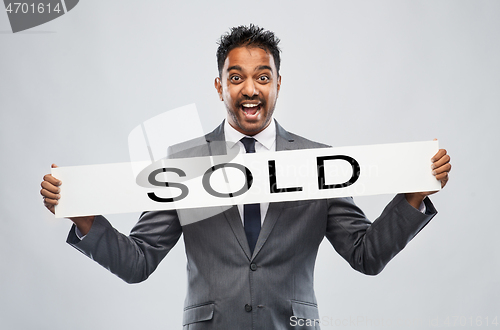 Image of happy indian male realtor with sold banner