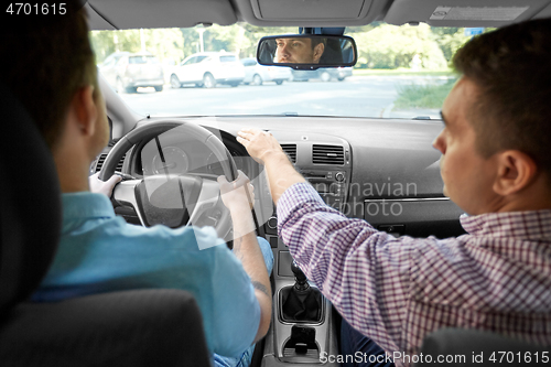 Image of car driving school instructor teaching male driver