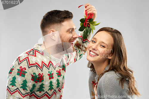 Image of happy couple kissing under the mistletoe