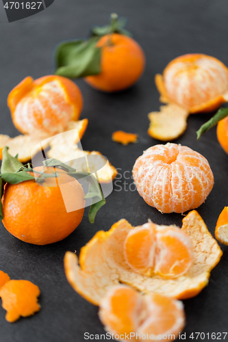 Image of close up of peeled mandarins on slate table top