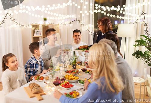 Image of happy family having dinner party at home