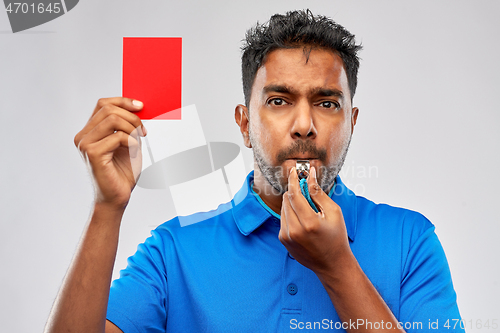 Image of indian referee whistling and showing red card