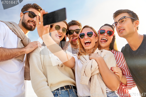 Image of happy friends taking selfie in summer