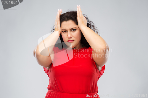 Image of woman in red dress suffering from headache