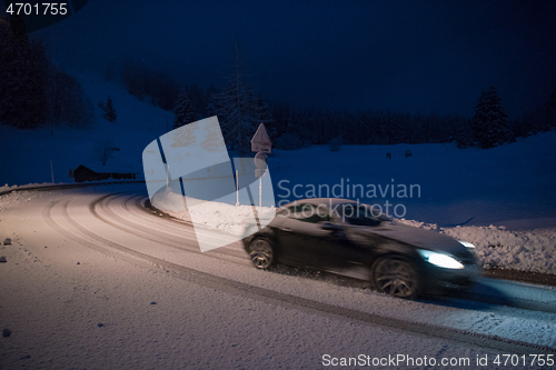 Image of car driving on dangerous road at night on snow