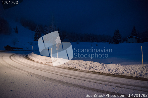 Image of car driving on dangerous road at night on snow