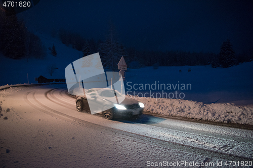 Image of car driving on dangerous road at night on snow