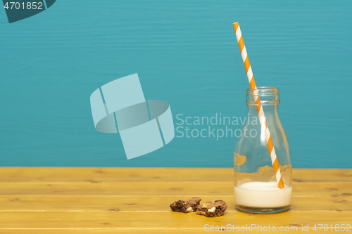 Image of Straw and bottle half full of milk, and cookie crumbs