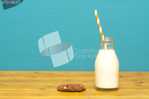 Image of Milk and paper straw in a bottle with a cookie