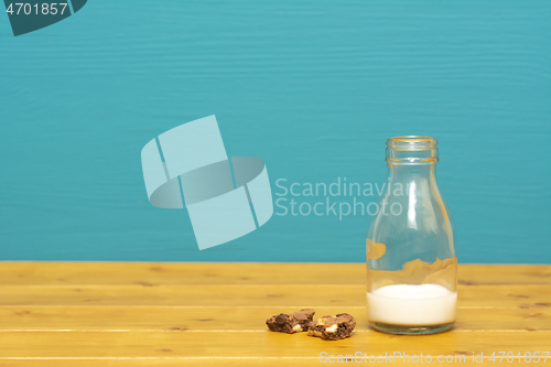 Image of Glass bottle half full of milk with cookie crumbs