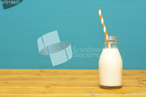 Image of Fresh milk with a paper straw in a glass bottle