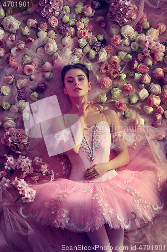 Image of Young woman in pink ballet tutu surrounded by flowers