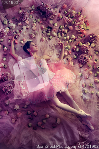 Image of Young woman in pink ballet tutu surrounded by flowers