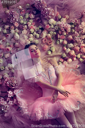 Image of Young woman in pink ballet tutu surrounded by flowers