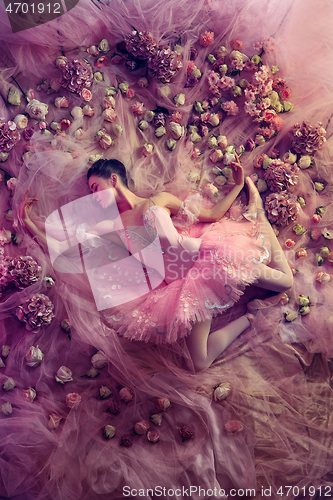 Image of Young woman in pink ballet tutu surrounded by flowers