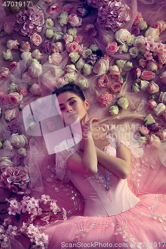 Image of Young woman in pink ballet tutu surrounded by flowers