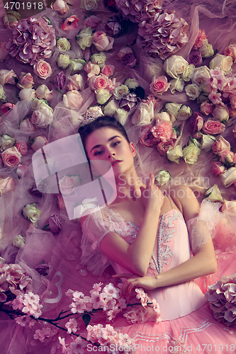 Image of Young woman in pink ballet tutu surrounded by flowers