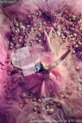 Image of Young woman in pink ballet tutu surrounded by flowers