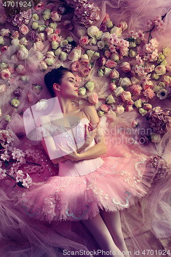 Image of Young woman in pink ballet tutu surrounded by flowers