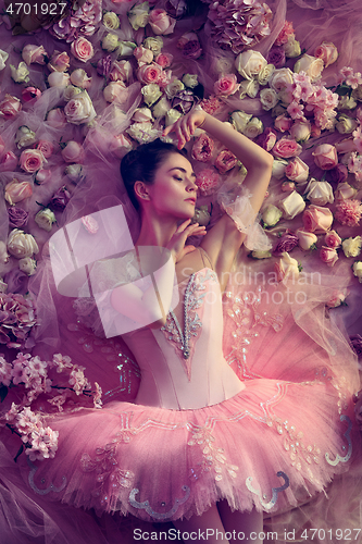 Image of Young woman in pink ballet tutu surrounded by flowers