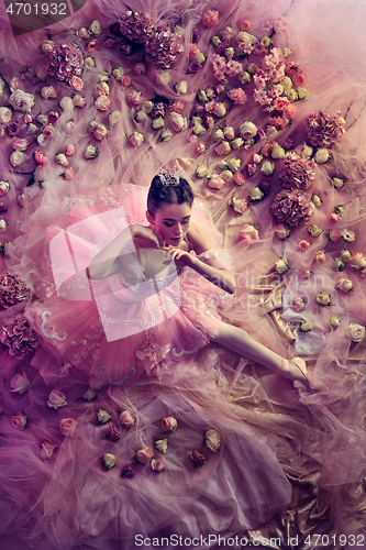 Image of Young woman in pink ballet tutu surrounded by flowers