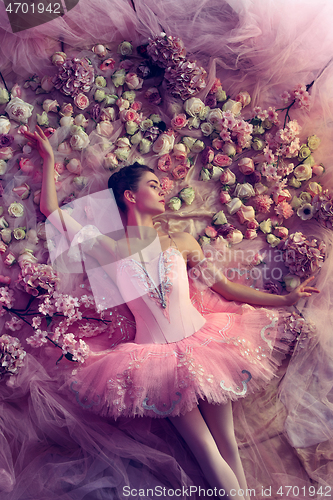 Image of Young woman in pink ballet tutu surrounded by flowers