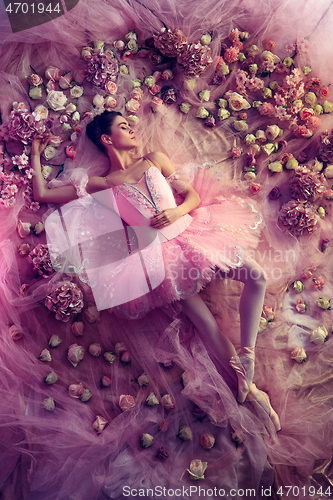 Image of Young woman in pink ballet tutu surrounded by flowers