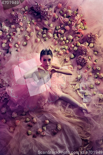 Image of Young woman in pink ballet tutu surrounded by flowers