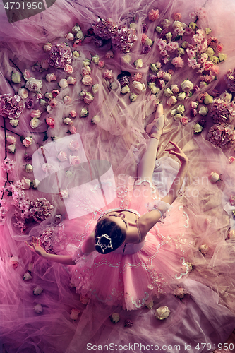 Image of Young woman in pink ballet tutu surrounded by flowers