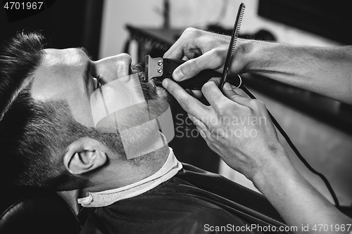 Image of Client during beard shaving at barbershop.