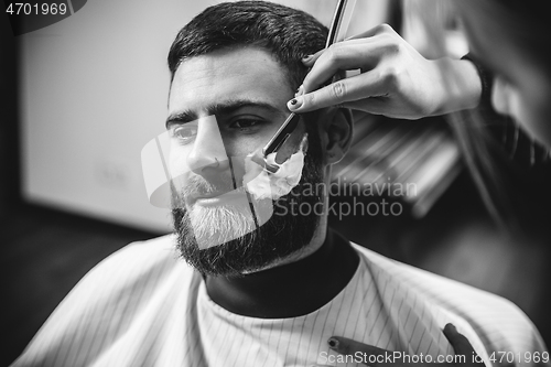 Image of Client during beard shaving in barber shop