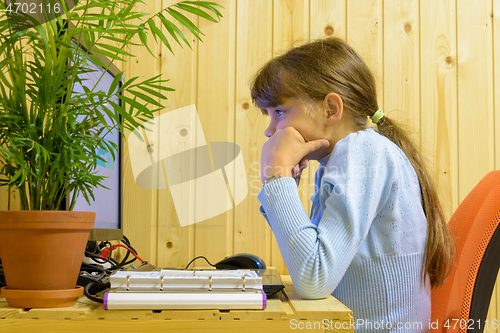 Image of The girl thought hard while solving a problem in the computer