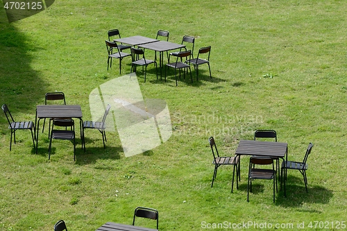 Image of chairs and tables on a green lawn