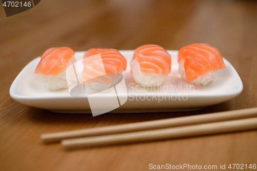 Image of chopsticks and sushi with salmon on the mat