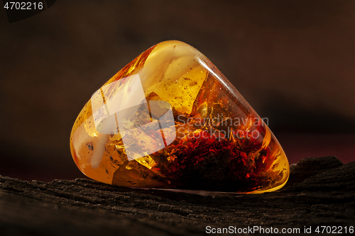 Image of Beauty of natural raw amber. A piece of yellow-red transparent natural amber with inclusions in it.