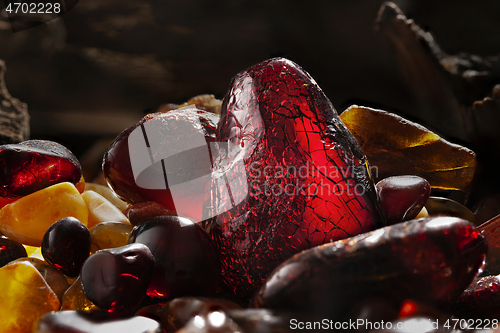 Image of Beauty of natural amber. Several dark red natural amber stones in a cave.