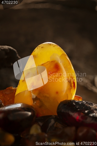 Image of Beauty of natural amber. Big bright yellow natural amber stone in a cave.