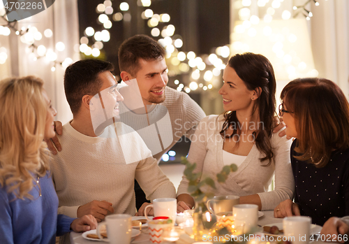 Image of happy family having tea party at home