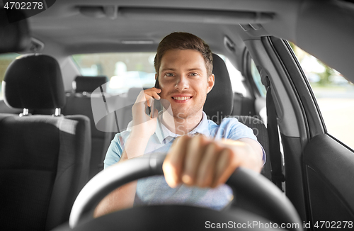 Image of man driving car and calling on smartphone