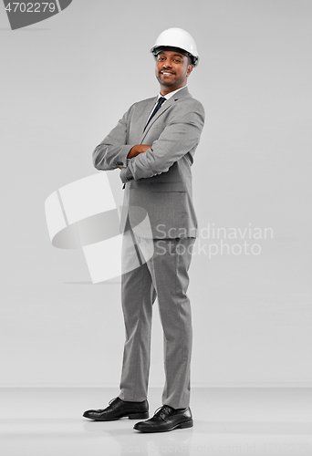 Image of smiling indian male architect in helmet over grey